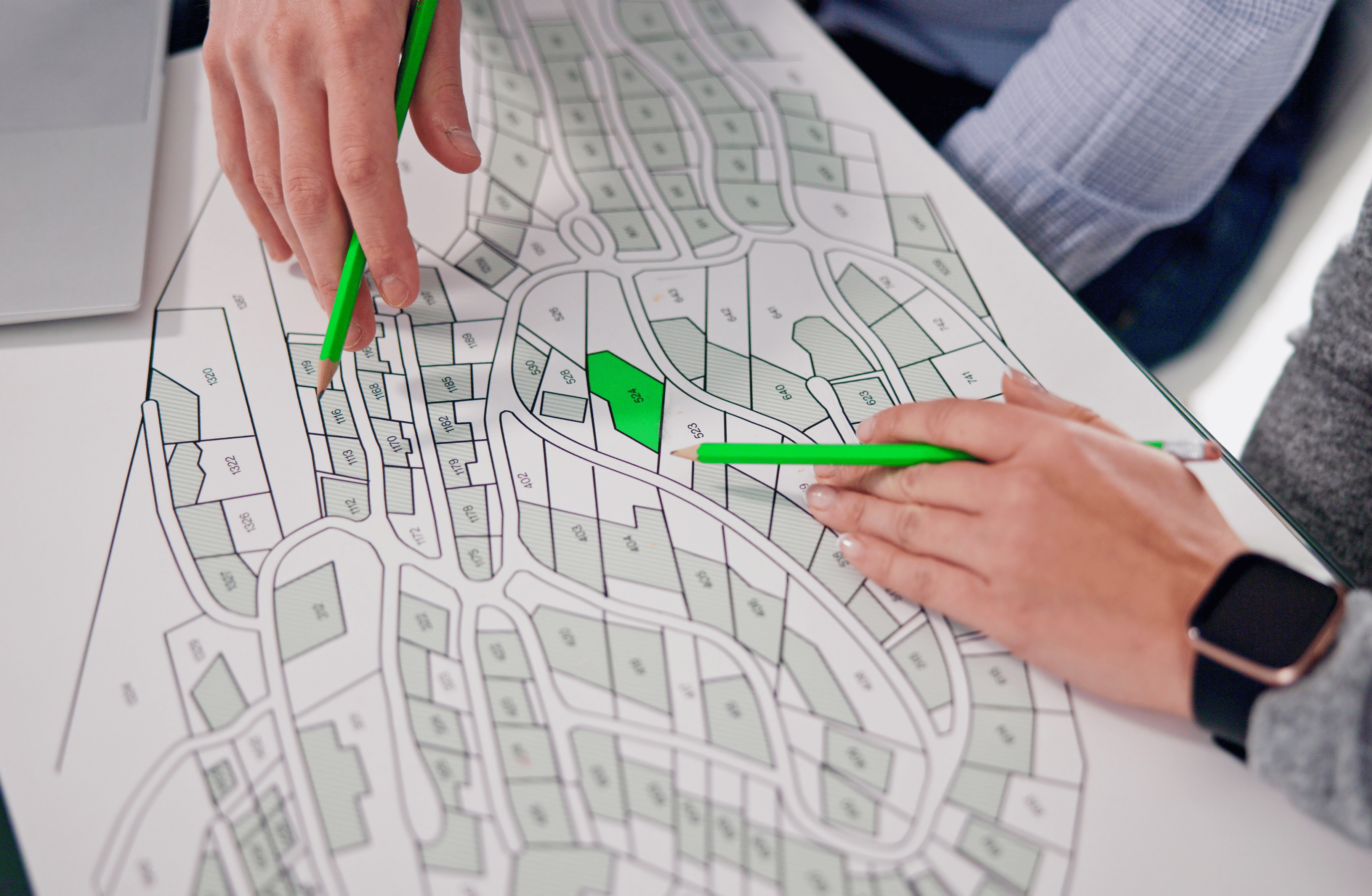 Stone Haven Developments Two people point at lots on a printed map with green pencils, discussing plots or land division details for Stone Haven Developments. Ontario
