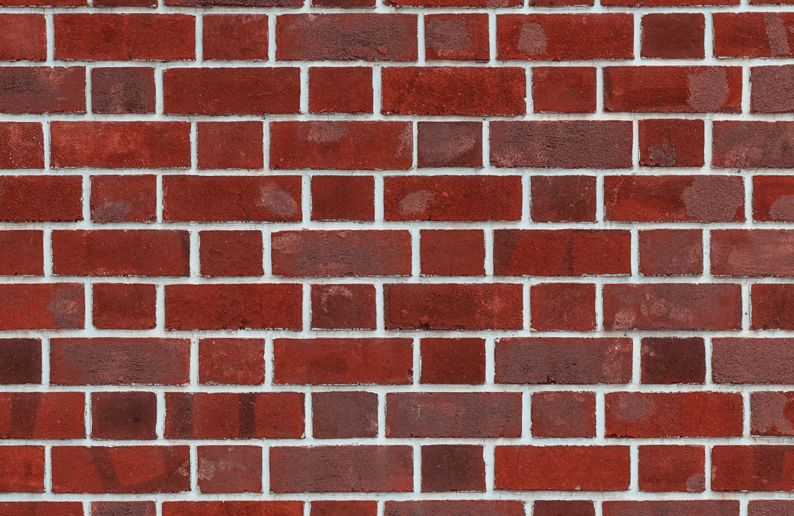 Stone Haven Developments A close-up view of a red brick wall with white mortar lines forming a regular rectangular pattern. Ontario