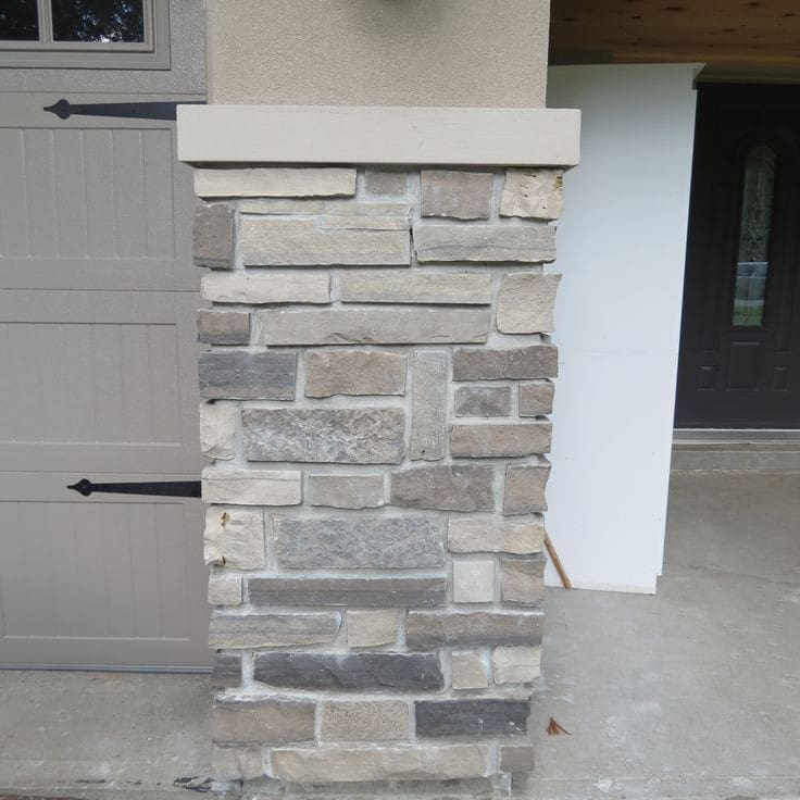Stone Haven Developments A stone-covered column stands beside a partially visible garage door and entryway, with a concrete floor and neutral-toned exterior. Ontario