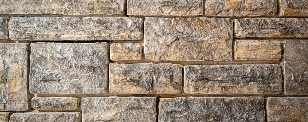 Stone Haven Developments Rectangular gray and beige stone blocks stacked in a horizontal pattern, forming a textured masonry wall. Ontario