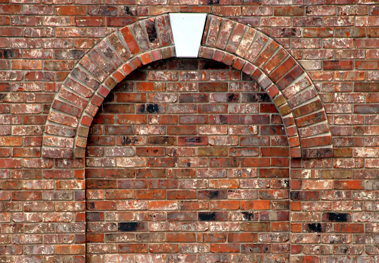Stone Haven Developments A brick wall with an arched design outlined in bricks and a single white keystone at the top, but the archway is filled in with matching bricks. Ontario